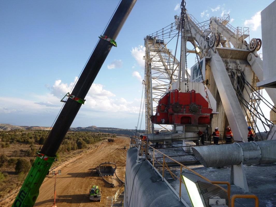 ABC crew in orange hi-vis on the deck of a Marion 8750 walking dragline as a crane holds the red propel gear case overhead, Bowen Basin