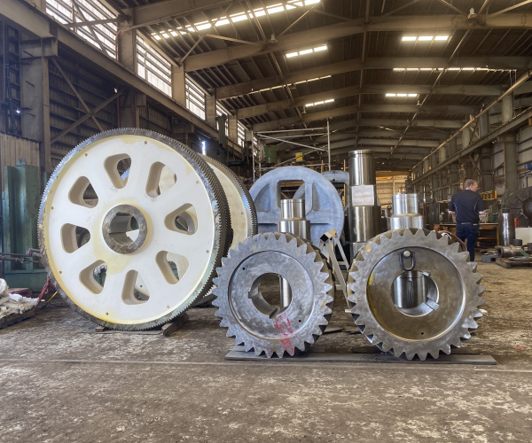 Three large fabricated gear blanks of increasing size standing upright on the ABC workshop floor